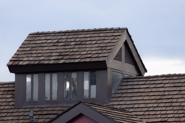 Poster - A house with a slanted roof and a window. garret house with wooden roof shingle.