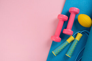 Wall Mural - Time for exercising sport equipment on the pink table background, healthy and workout concept