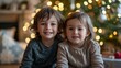 © esp2k - Two young children are posing for a picture in front of a Christmas tree