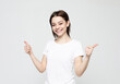 © Raisa Kanareva - Successful young woman gives thumbs up with two hands over grey background.