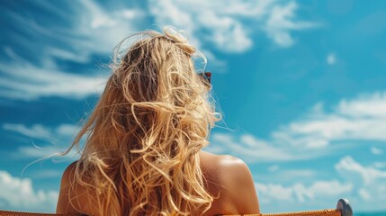 Wall Mural - Beautiful blonde woman laying in beach chair looking at blue sky