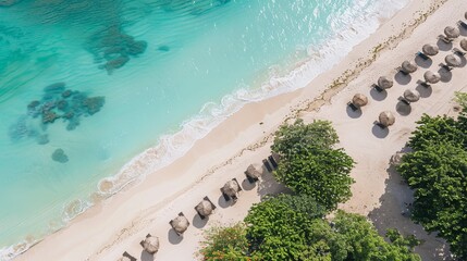 Wall Mural - The image displays a beautiful, pristine beach with clear turquoise water and a series of straw huts along the shoreline, encapsulating the essence of a perfect tropical getaway.