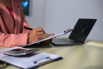 Image of a young Asian female company employee smiling and holding a digital tablet standing on a white background.