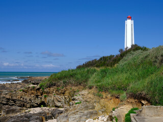 Wall Mural - Armandeche lighthouse on rocky coast at Les Sables d’Olonne, commune in the Vendee department in the Pays de la Loire region in western France