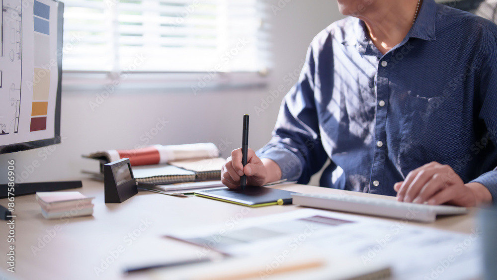 Interior designer senior man writing in digital tablet and typing data ...