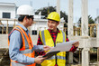 © Phushutter - Two male construction workers, including an Asian engineer, meticulously review structural plans and design concrete columns and beams for a new residential build.