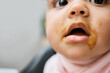 © KayJoint/peopleimages.com - Baby, mouth and girl with messy eating for nutrition, child growth and home kitchen. Youth, hungry and kid ready in morning, children high seat and house for food, meal and future development