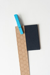 Wall Mural - blue crafting clothespin clipped to a brown paper stripe and square on blank paper