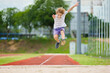 © famveldman - Kids long jump athletics training. Child jumping.