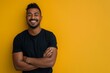 © pham - A man with short, dark hair smiles and stands with his arms crossed in front of a bright yellow wall