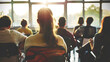 © Gita - A group of students seated in a classroom, attentively facing the teacher at the front. Sunlight streams through the large windows, creating a warm and focused learning environment.