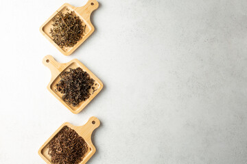 Wall Mural - A top down view of assorted loose leaf tea on bamboo saucers, on the left side of the frame.