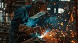 © Agi - man welds metal in factory
