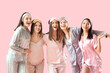 © Pixel-Shot - Young women in pajamas hugging on pink background. Hen Party