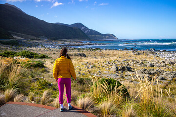 Wall Mural - tourist girl enjoys a sunset at paparoa point scenic reserve, new zealand south island