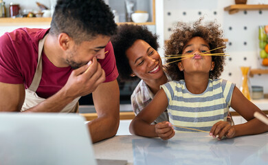 Wall Mural - Happy african family having fun with device at home. Black parents and child using digital tablet