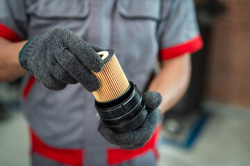 Wall Mural - Close up hand of Auto Mechanic with Oil and fuel filter changing.