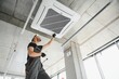© Serhii - Happy Male Technician Repairing Air Conditioner