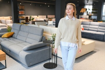 Wall Mural - young woman shopping for furniture, sofa and home decor in store