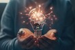© Minerva Studio - Closeup of hands holding a bright brain light bulb, symbolizing creativity and innovation