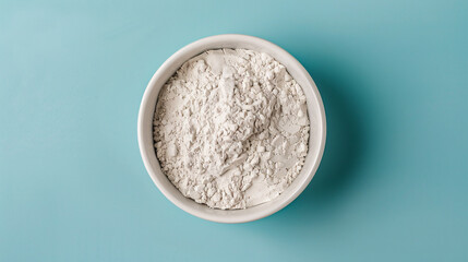 Wall Mural - White powder in a bowl on blue background.