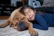 © alisaaa - Love My Pet Dog A visually impaired shar-pei pet dog kisses a young girl who is a member of the family. They are both lying on the floor. The girl has an excited, positive emotion on her face.