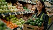 © Aziz - Latin woman working in supermarket holding a box containing fresh avocados