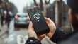 © fumoto-lab - 街中でWi-Fiの電波を探すスマートフォンを持った男性