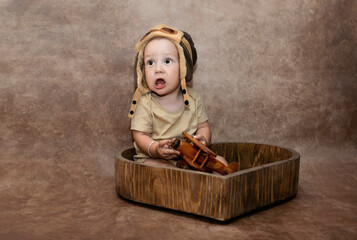 1-year-old baby with a pilot's cap and a toy airplane