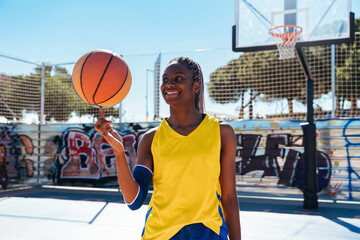 Black female basketball player training at city basketball court