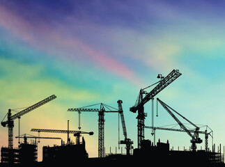 Poster - house building and cranes on multycolors sky background