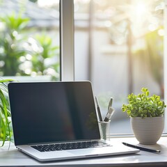 Wall Mural - Laptop on a desk with a notepad and pen. Bright natural light. Home office background.  