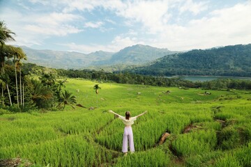 traveling women enjoying the view of the green valley full of rice terraces, river and mountains in 
