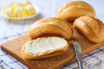 Wall Mural - Butter and bread for breakfast over white kitchen table, selective focus.