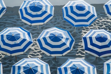 Leinwandbilder - Precise Aerial View of Symmetrical Blue and White Striped Beach Umbrellas on Sandy Shore