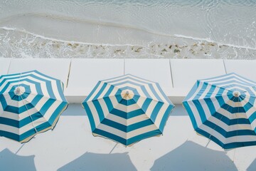 Poster - Aerial View of Symmetrical Blue and White Striped Beach Umbrellas by the Ocean