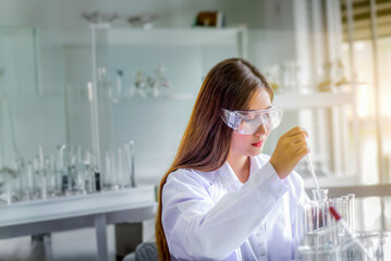 Wall Mural - attractive young asian scientist woman lab technician assistant analyzing sample in test tube at lab