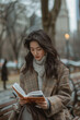 © TANAT - 31 An Asian fashion model in casual attire, reading a book on a park bench in a bustling city