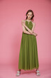 © SBekhinov - High fashion photo of a beautiful elegant young skinny woman in pretty long green dress posing on pink background. Slim figure.