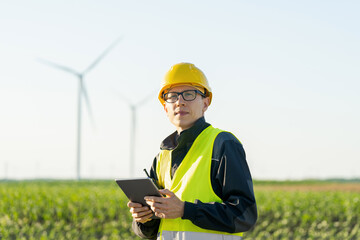 Aufkleber - Engineer with digital tablet works on a field of wind turbines	
