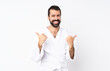 © luismolinero - Young man doing karate over isolated white background with thumbs up gesture and smiling