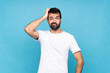 © luismolinero - Young man with beard  over isolated blue background with an expression of frustration and not understanding