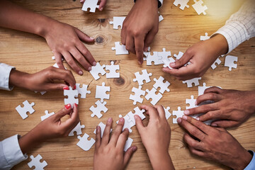 Poster - Above, hands and business people with puzzle in table for problem solving, inclusion and strategy. Employees, partnership and collaboration for innovation or solution with team building and support