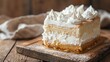 © GoodRNG - A closeup of a Colombian tres leches cake, showing its moist, milksoaked layers and whipped cream topping, placed on a rustic wooden board with natural lighting