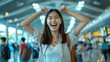 © Adi - Young woman feeling excited while going on vacation at airport