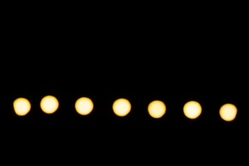 Wall Mural - a row of yellow lights on a black background
