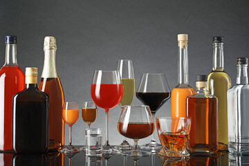 Sticker - Bottles and glasses with different alcoholic drinks on table against gray background