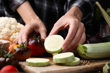 Wall Mural - Cooking vegetable stew. Woman with cut zucchini and tomato at table, closeup