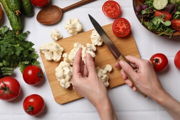 Sticker - Healthy vegetarian food. Woman cutting cauliflower at white tiled table with vegetables, top view