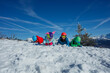 © Sergey Novikov - Family lying on snow, surrounded by majestic mountain scenery